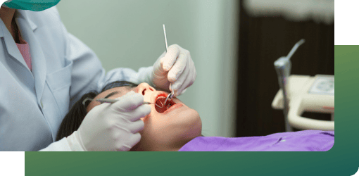 Girl lying in a dental chair while a dentist examines her teeth to assess infection.