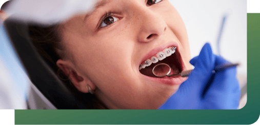 Dentist using magnification lenses to check a patient's dental braces in clinic.