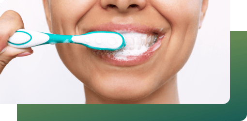 Person brushing teeth with a blue and white toothbrush, following instructions for professional teeth-whitening products to maintain a sparkling smile.