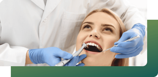 Dentist performing a root canal procedure, cleaning and filling the tooth using dental instruments to restore oral health of patient.