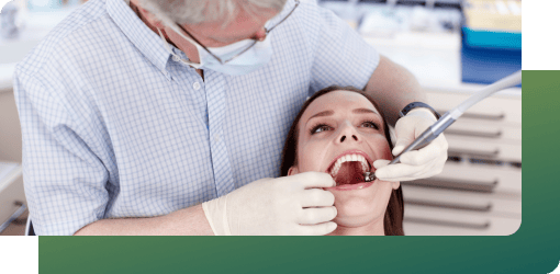A senior dentist assessing a patient's teeth.