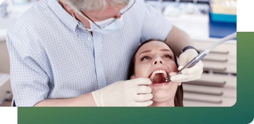 A senior dentist assessing a patient's teeth.