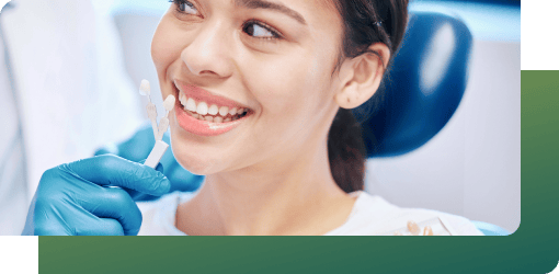 Smiling woman receiving a dental crown fitting, showcasing improved functionality and aesthetics for damaged teeth.
