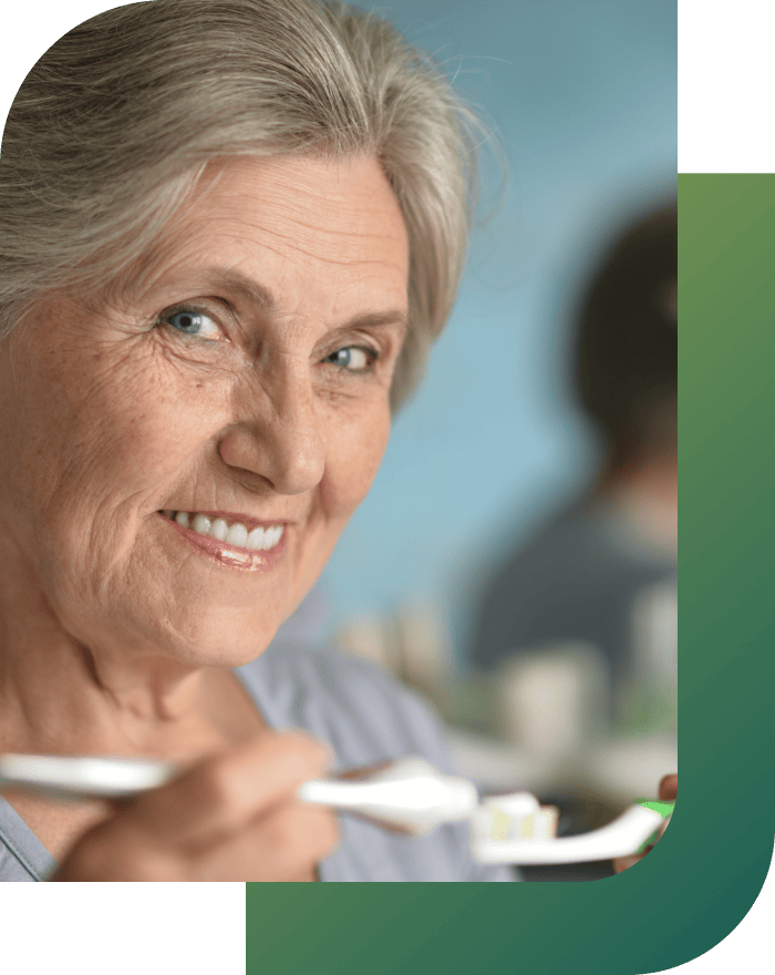 An elderly woman ready to brush her teeth.