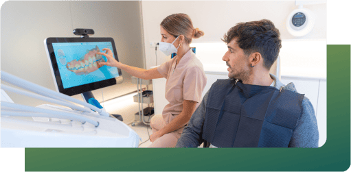 A dentist observes a deep examination of the patient's teeth displayed on a screen.