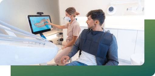 Professional explaining diagnostic assessments for dental abscess treatment to a patient using a digital display.