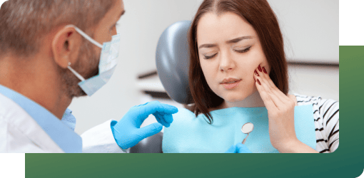A female patient experiencing pain consults her family dentist.