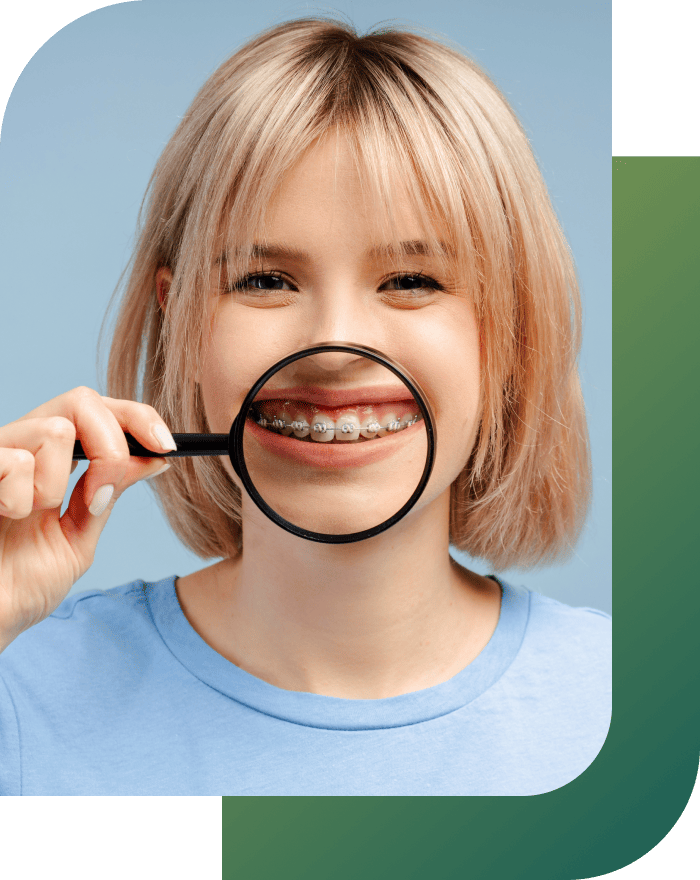 A woman smiling and showing her teeth with braces through a magnified lens.