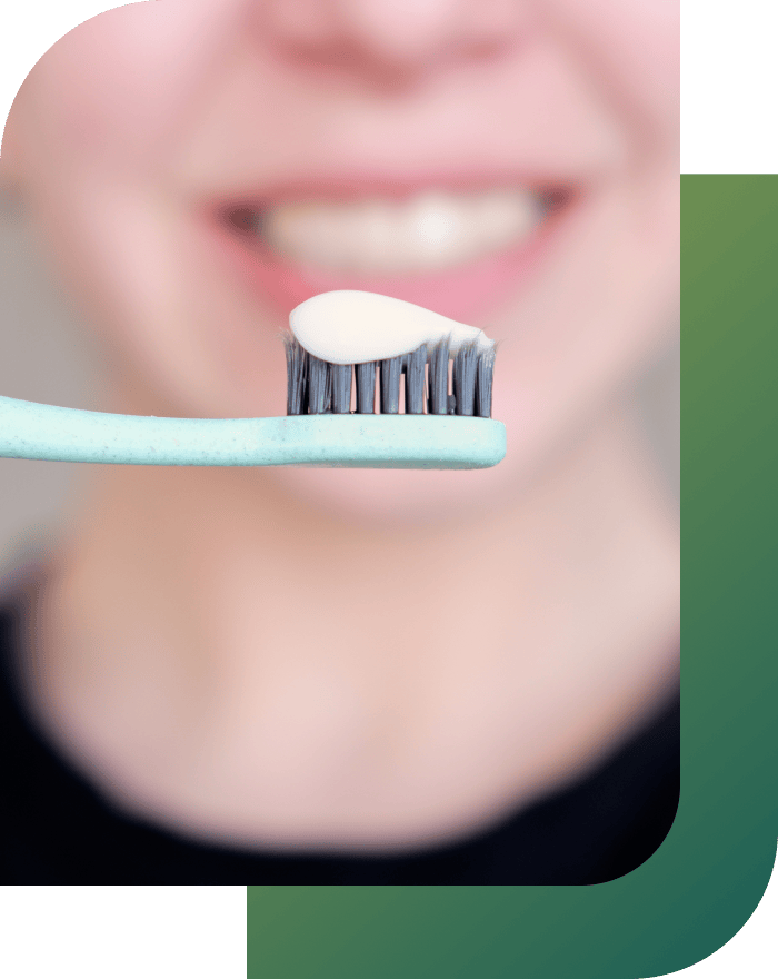 Close-up of a girl holding a toothbrush with toothpaste, illustrating dental restoration tip.