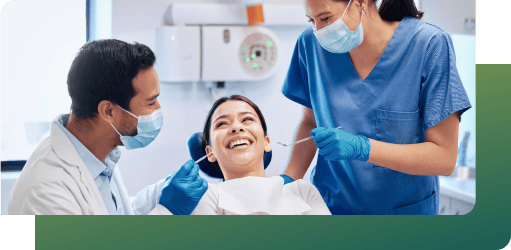 A dental expert and assistant smile with a patient, ensuring dental infection control with hand hygiene, face masks, and PPE.