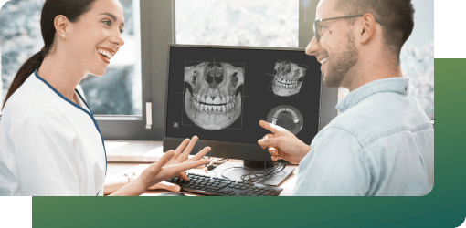 A doctor and patient having a consultation, with an X-ray of teeth displayed.