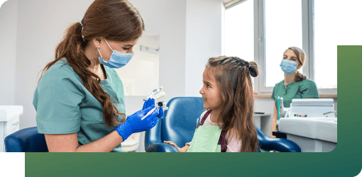 A happy kid receiving an initial consultation from a dentist.