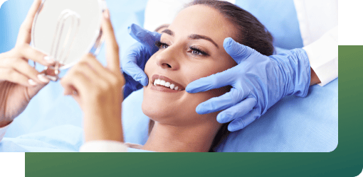 A patient viewing her teeth in the mirror after treatment, highlighting the results.