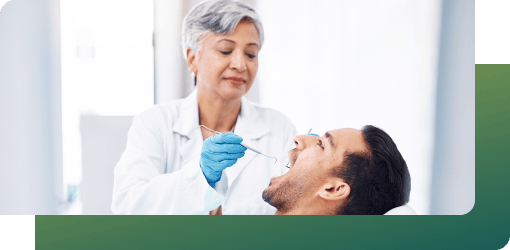 A dentist examining a male's teeth, gathering data through photos, X-rays, and impressions for Clear Aligners assessment.