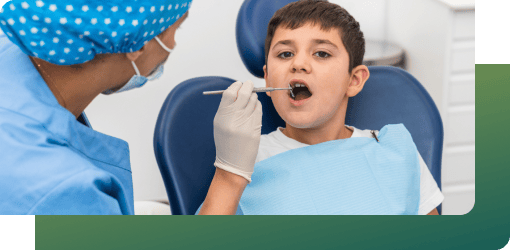 A dentist monitoring a boy's teeth with a dental tool in a clinic, ensuring regular follow-ups in children's orthodontics.