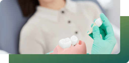 A dentist uses a syringe on a dental model to show anesthesia and emergency tooth extraction preparation.