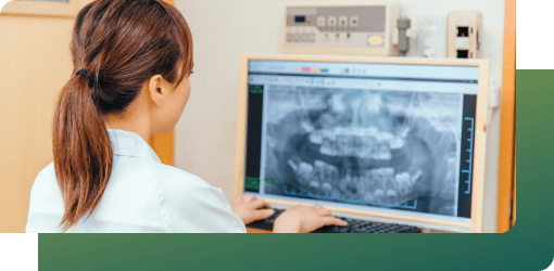A dentist monitoring a digital X-ray on the computer, planning clear aligner wear and regular check-ups to track progress.