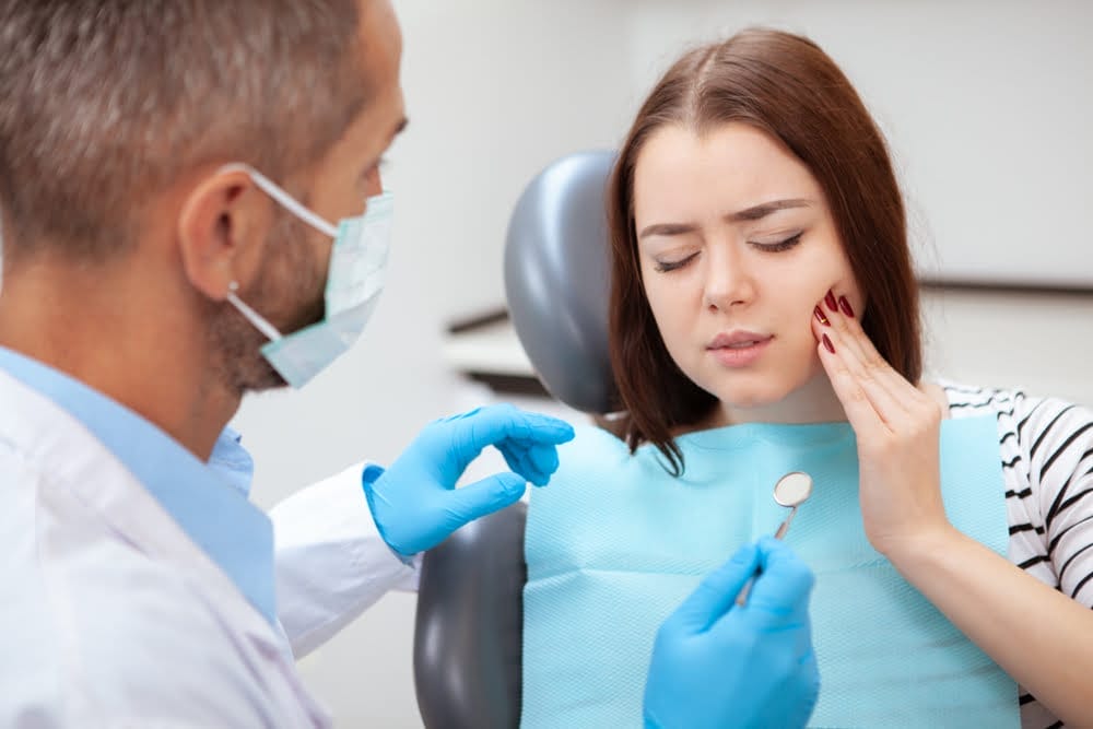 Dentist consults a patient about a painful dental emergency.